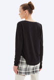 Woman wearing a black sweater and plaid skirt on a white background