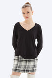 Woman wearing a black top and plaid skirt on a white background