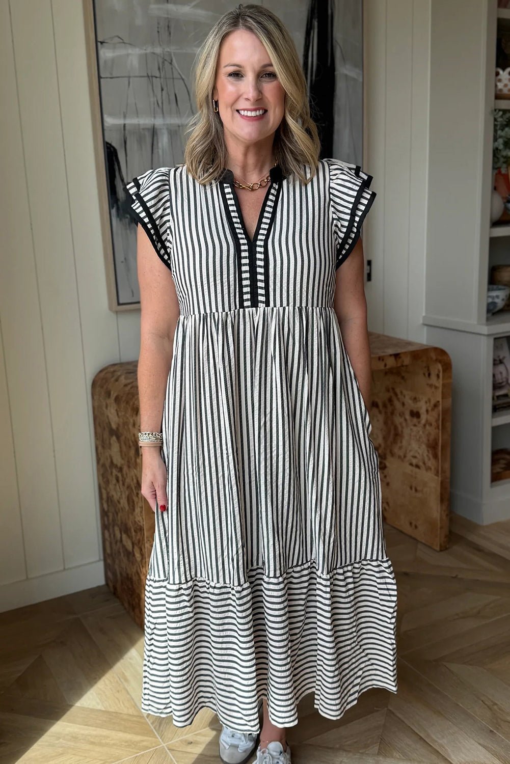Woman wearing a black and white striped dress indoors.