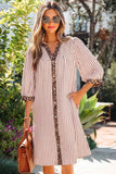 Woman wearing a striped dress with leopard print accents outdoors.