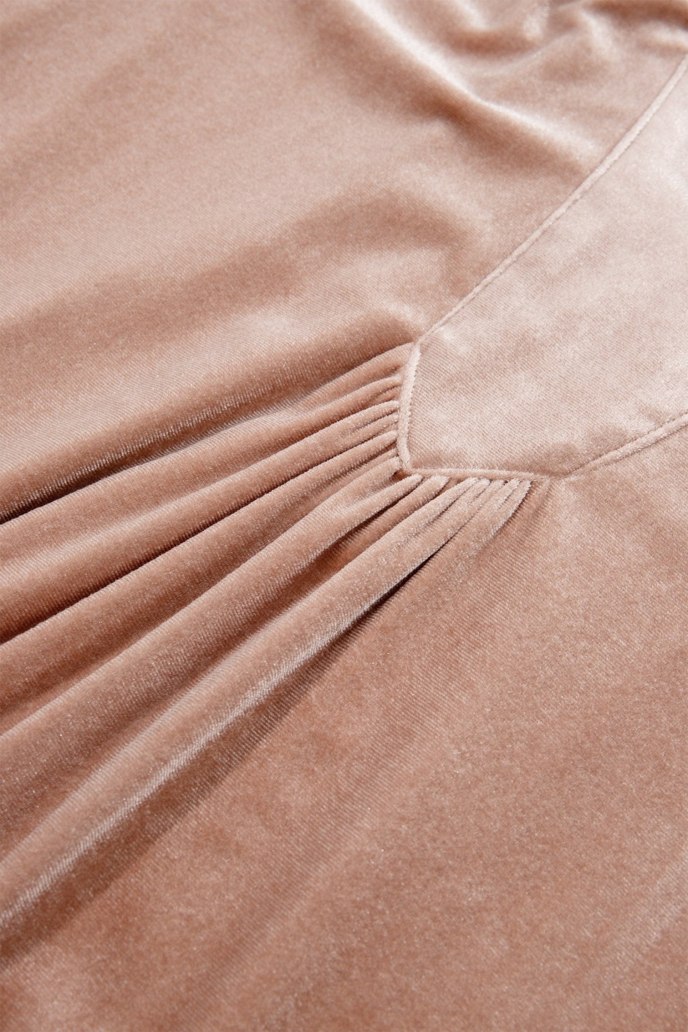 Close-up of a dusty rose velvet fabric with a V-neckline and gathered pleated detail.