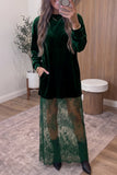Woman in dark green velvet dress with sheer lace overlay and black boots.