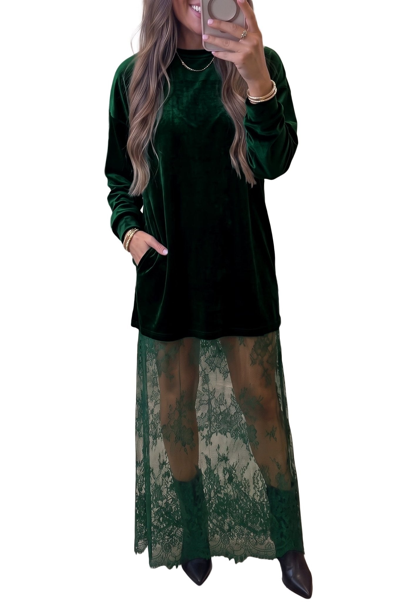 Woman in dark green velvet tunic with sheer lace skirt and black boots.