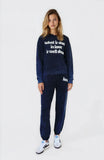 Woman wearing a navy tracksuit with text on a white background