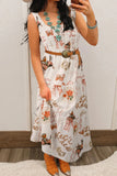 Woman wearing a floral dress with a belt, standing against a neutral background.