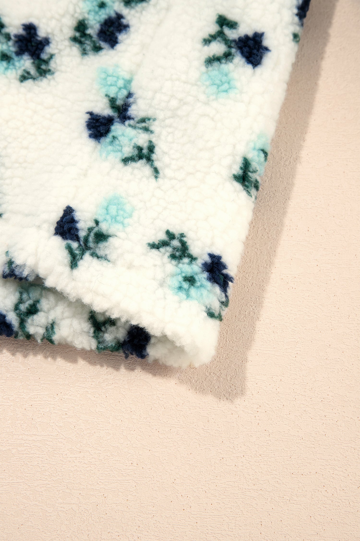 Hem detail of white floral faux fur sherpa jacket