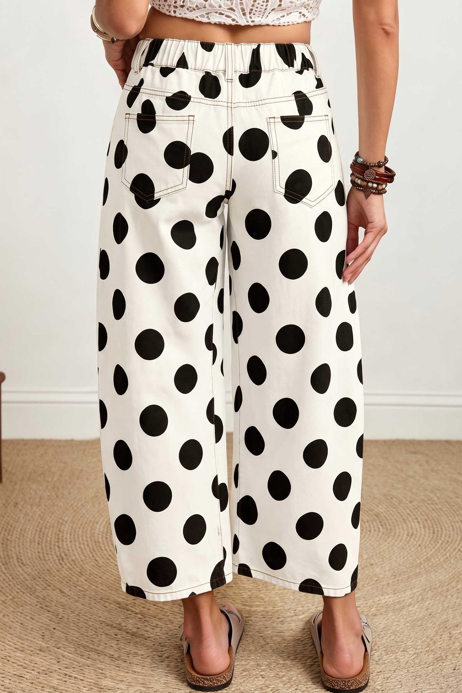 Back view of white polka dot barrel leg jeans with slide sandals