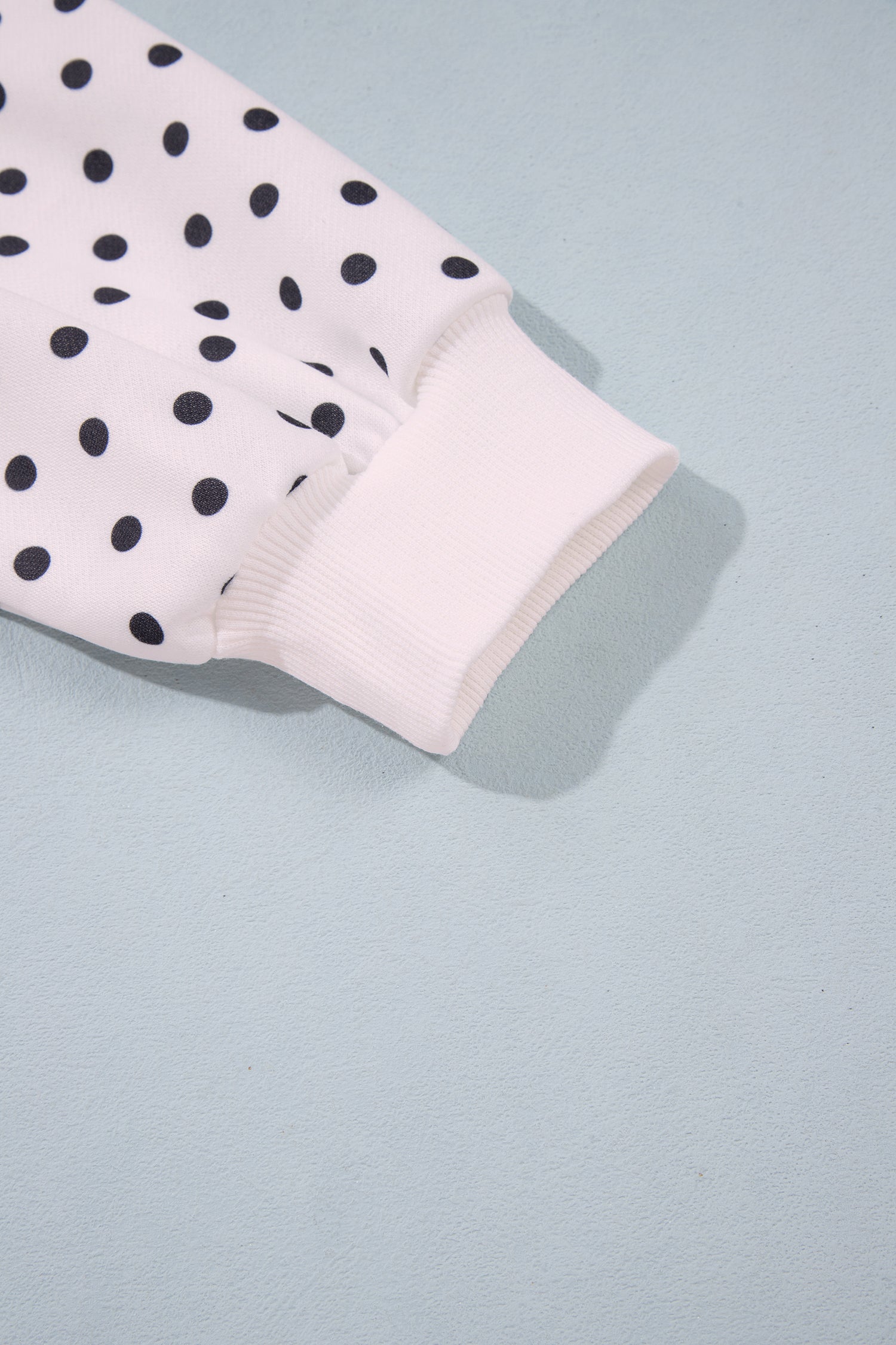 Ribbed cuff on white polka dot balloon sleeve, close-up