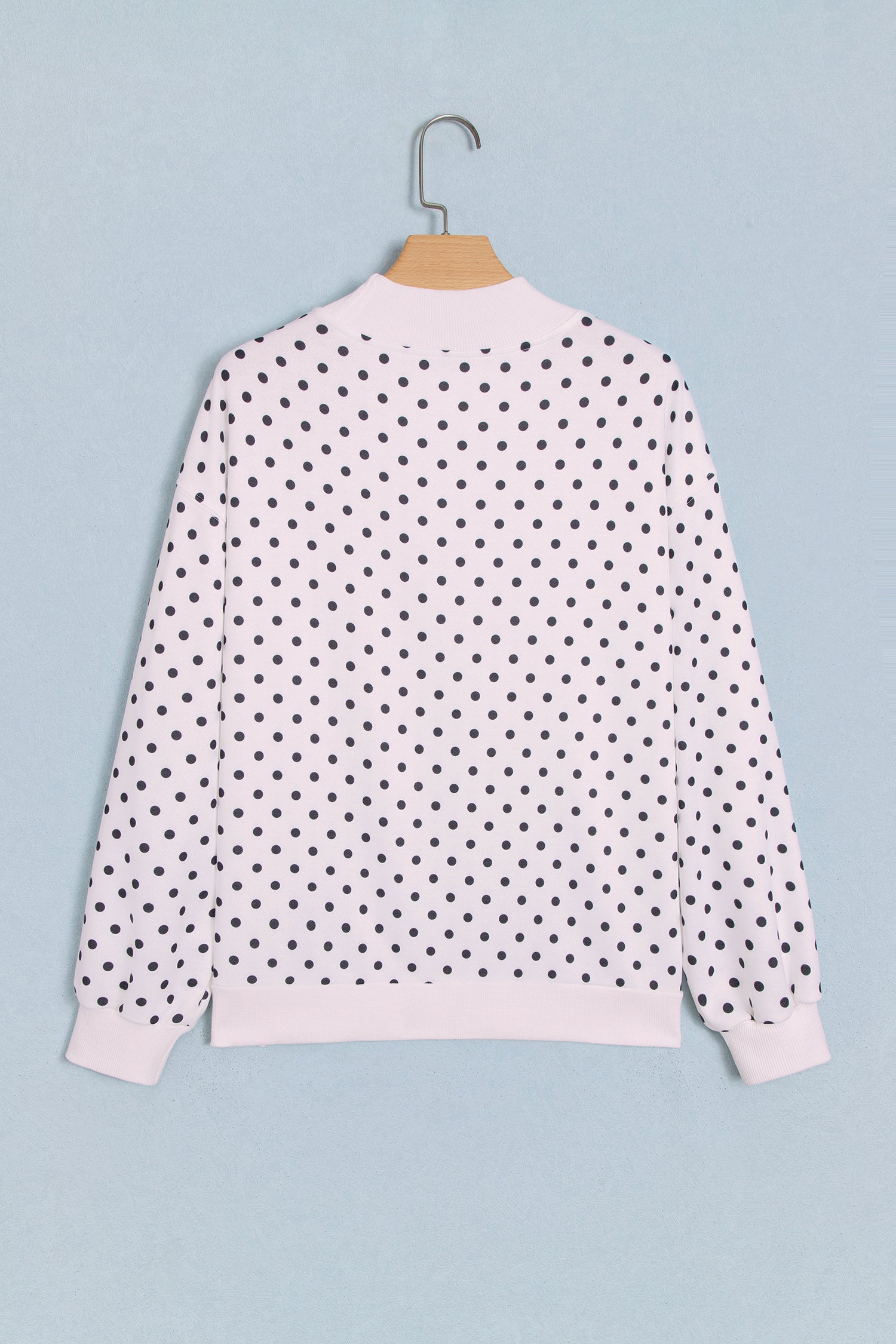 White polka dot mock neck sweatshirt on hanger, back view