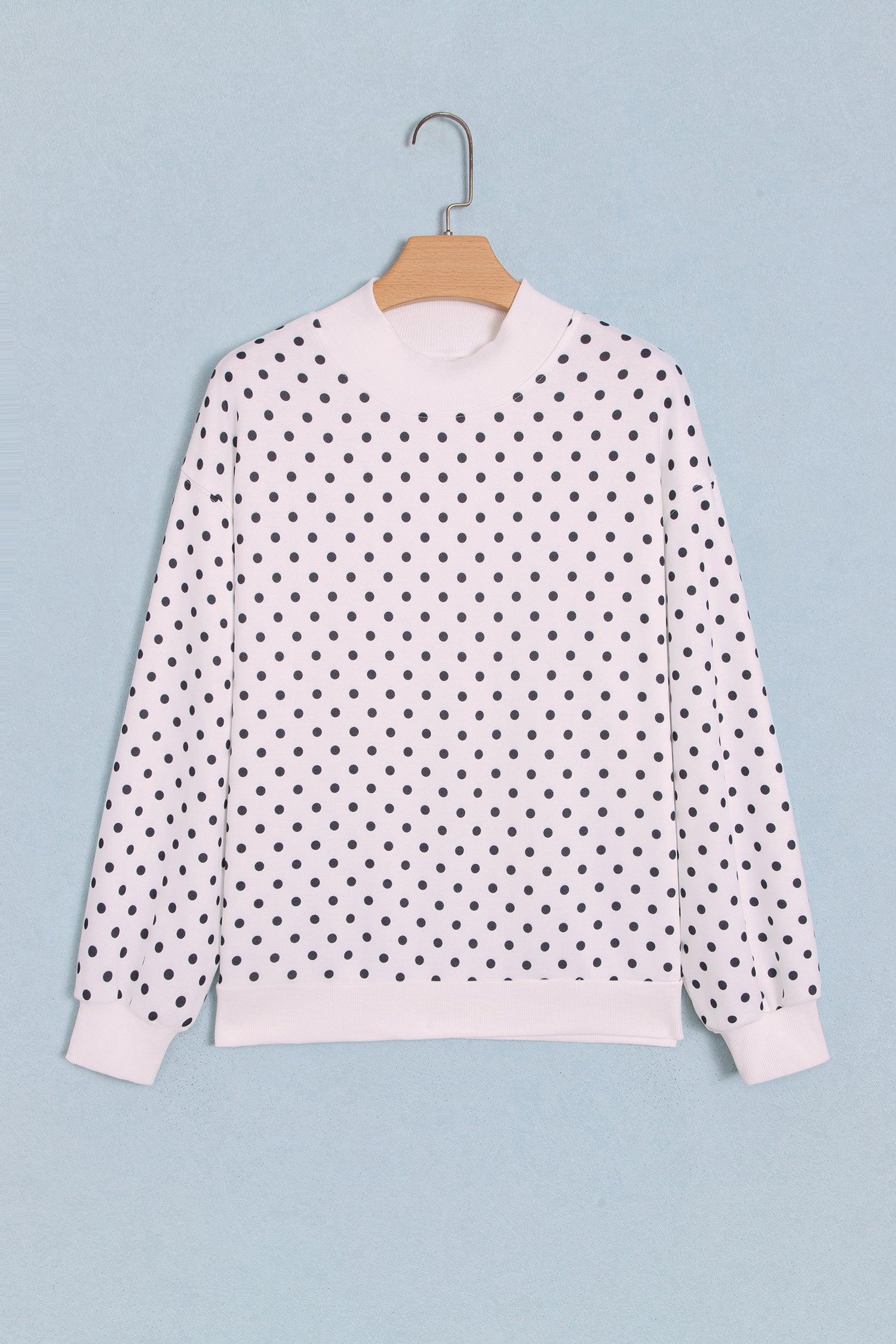 White polka dot mock neck sweatshirt on hanger, front view
