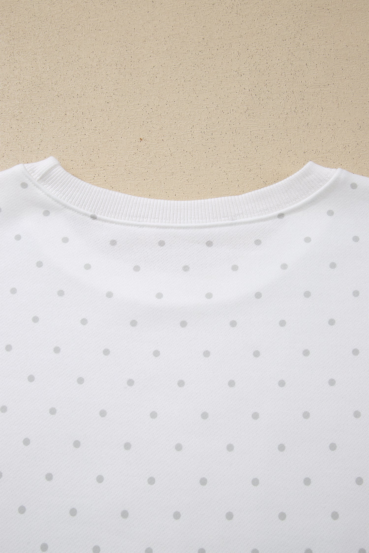 Back neckline detail on white polka dot sweatshirt