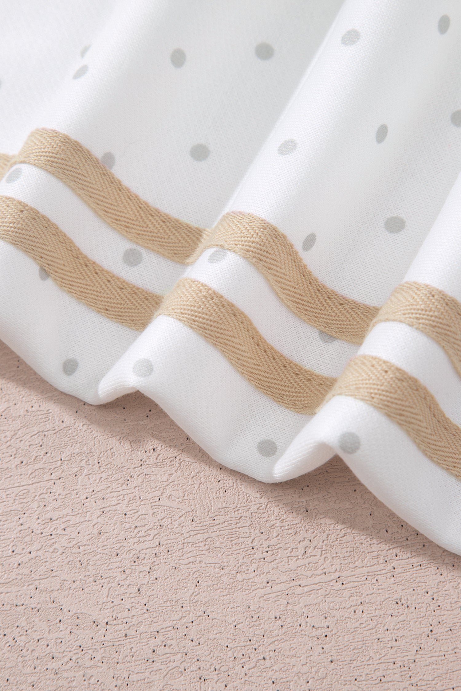 Beige and white side stripes on polka dot sleeve, close-up