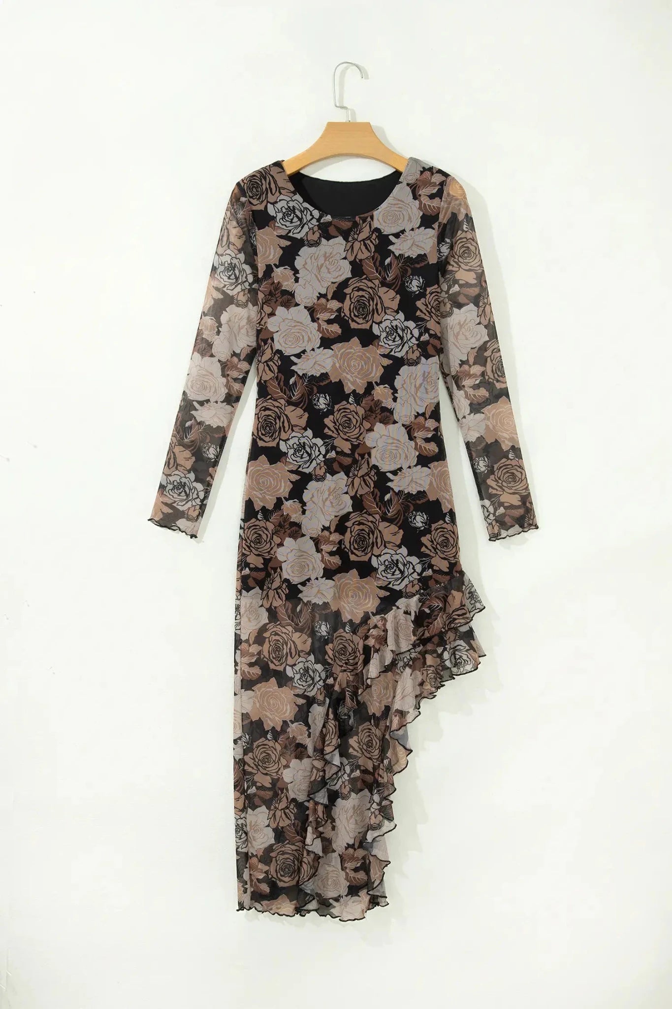 A long-sleeve midi dress with a sheer black mesh base and a brown, beige, and gray floral print, hanging on a wooden hanger against a plain white wall.