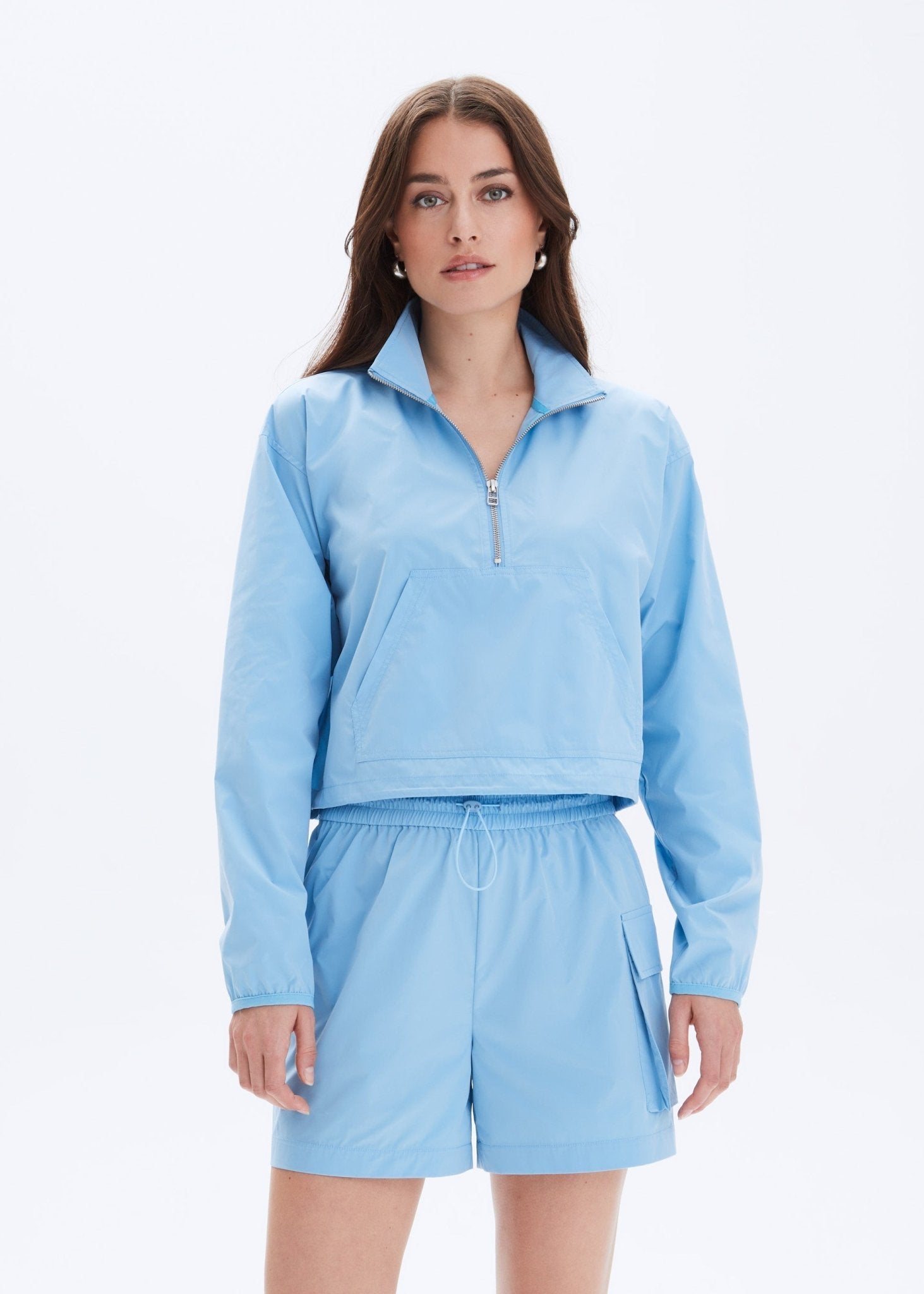 Woman wearing a light blue outfit on a white background