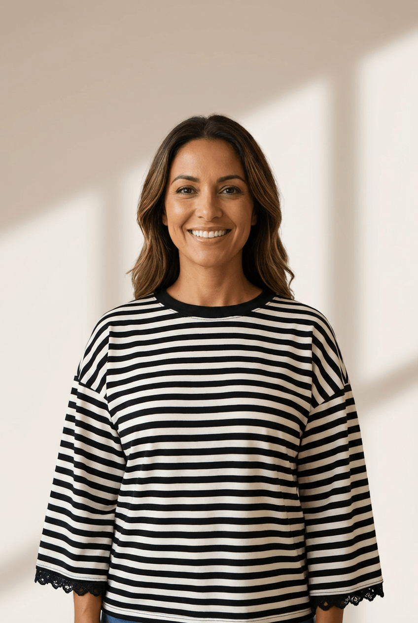 Woman wearing a black and white striped shirt against a neutral background