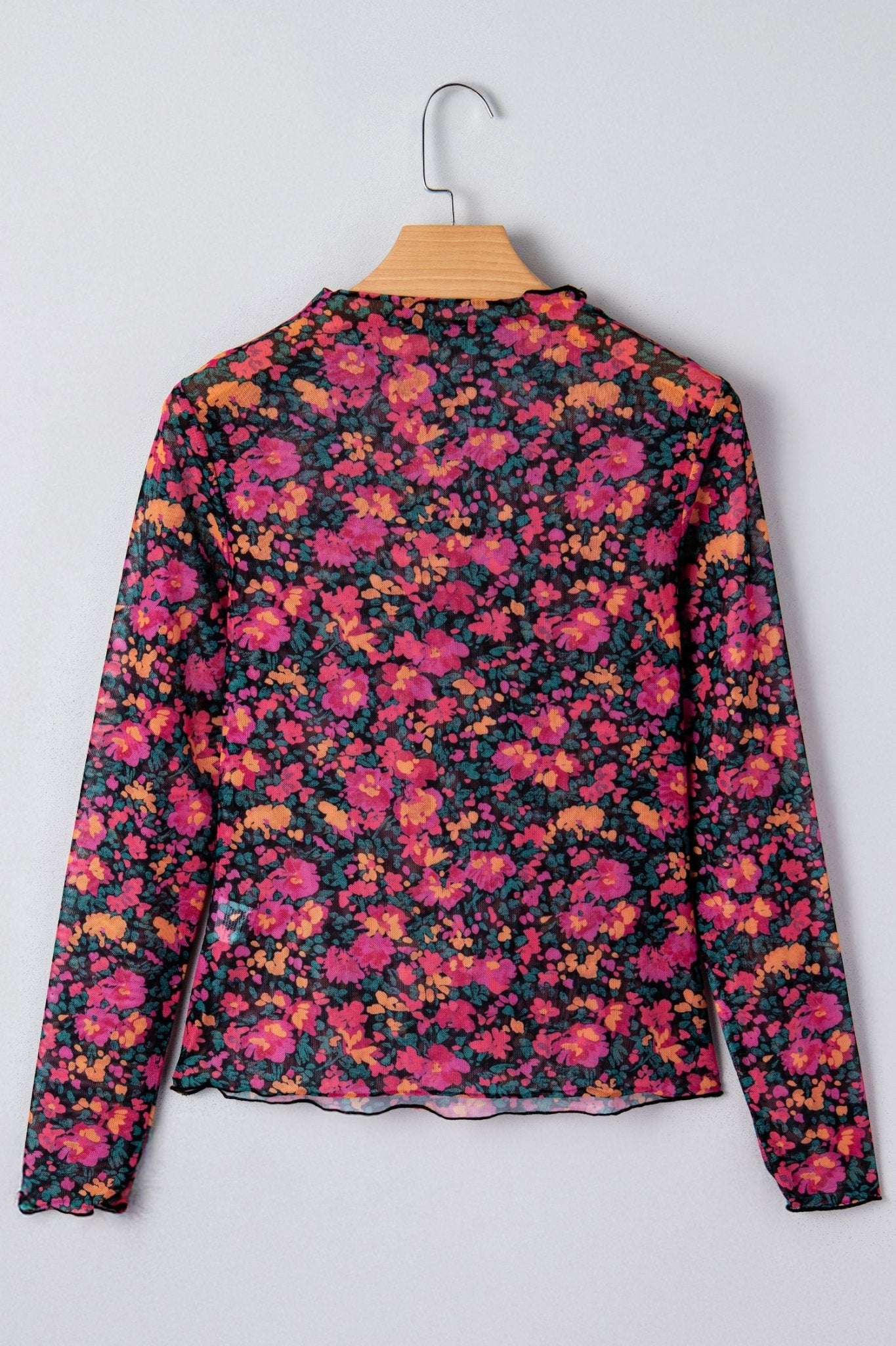 Floral patterned top on a hanger against a light gray background