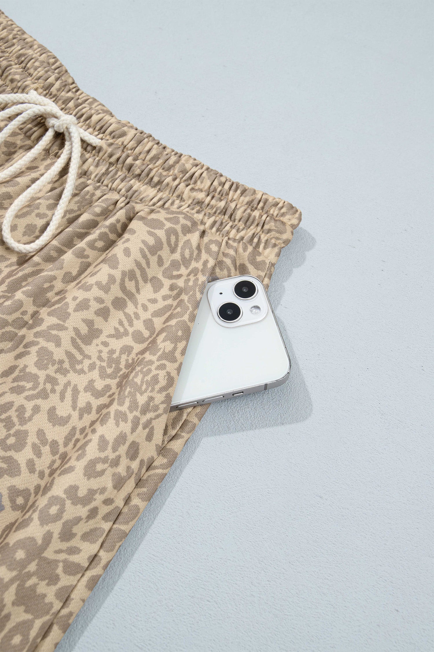 Khaki leopard pants side pocket holding a phone
