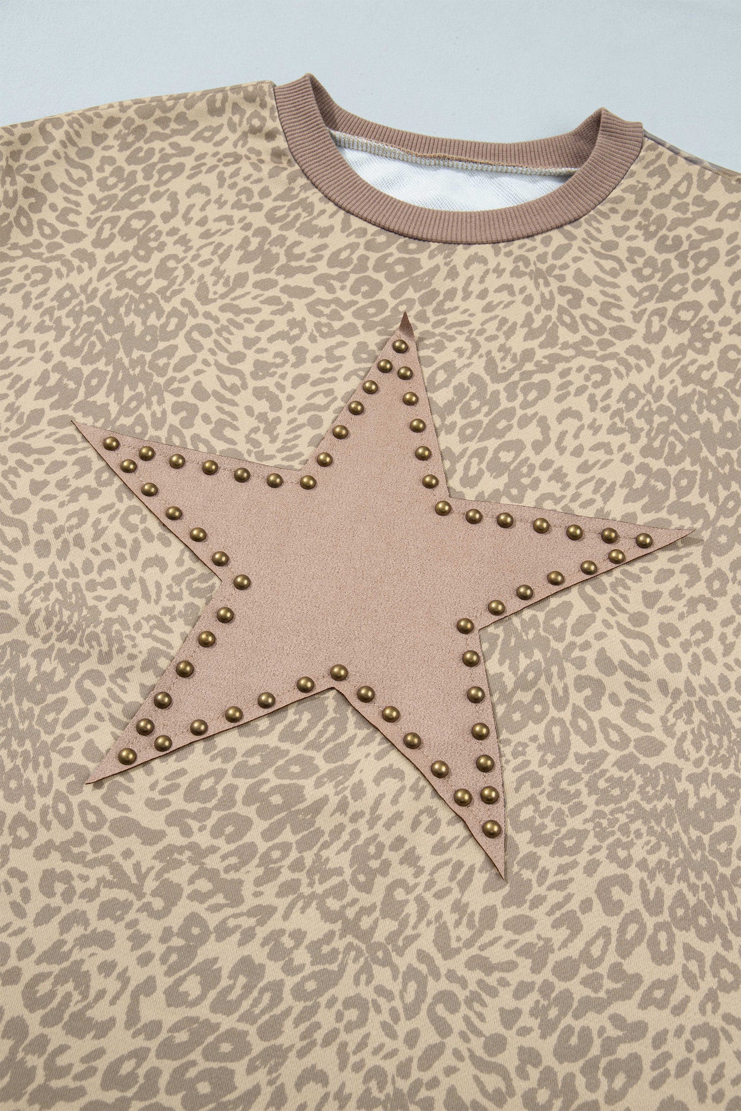 Leopard print top with star patch outlined in gold-tone studs