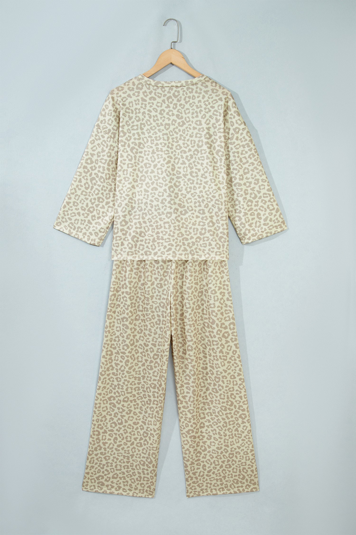 Apricot leopard print top and pants set on a hanger, back view