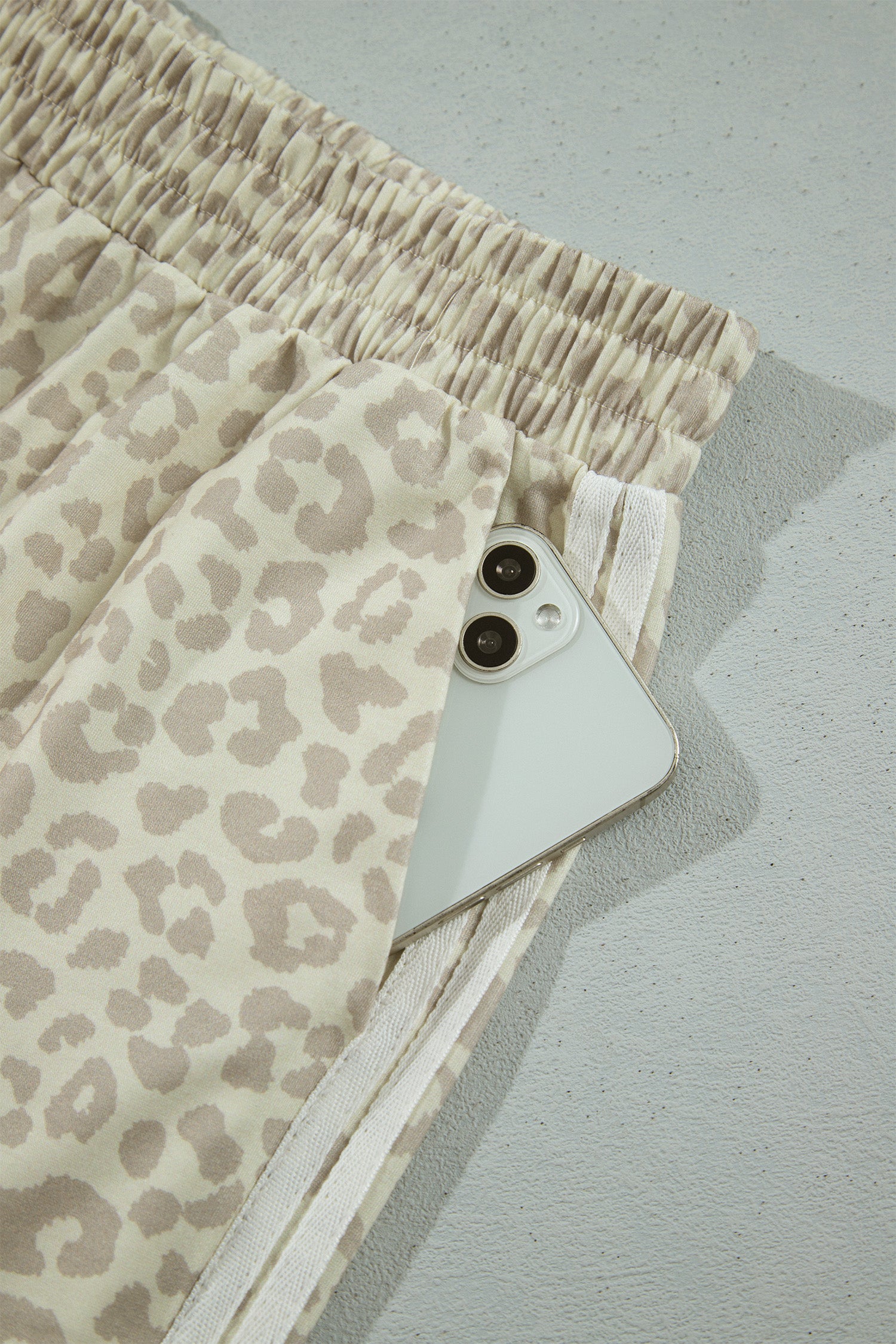 Apricot leopard pants side pocket holding a phone