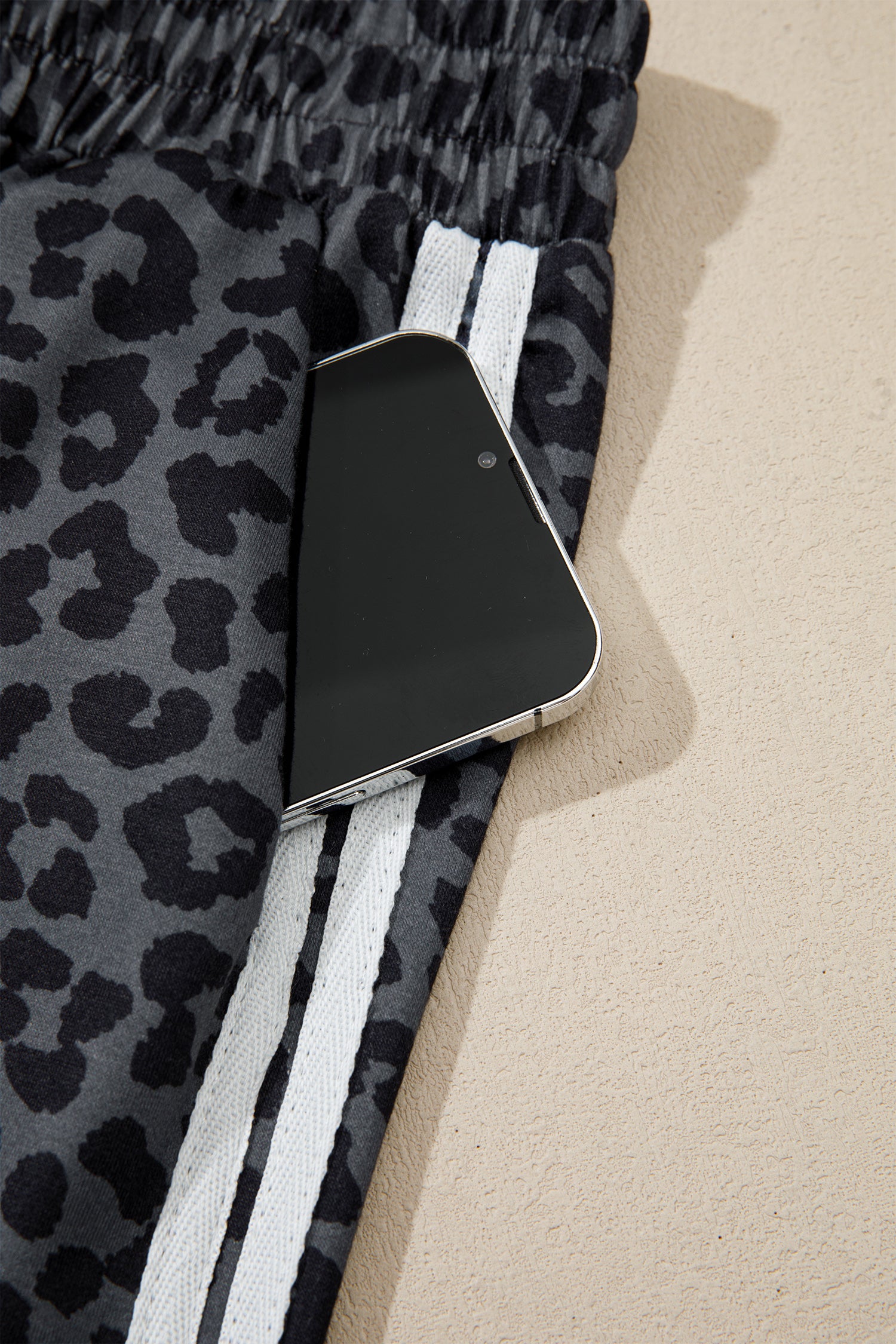 Gray leopard pants side pocket holding a phone