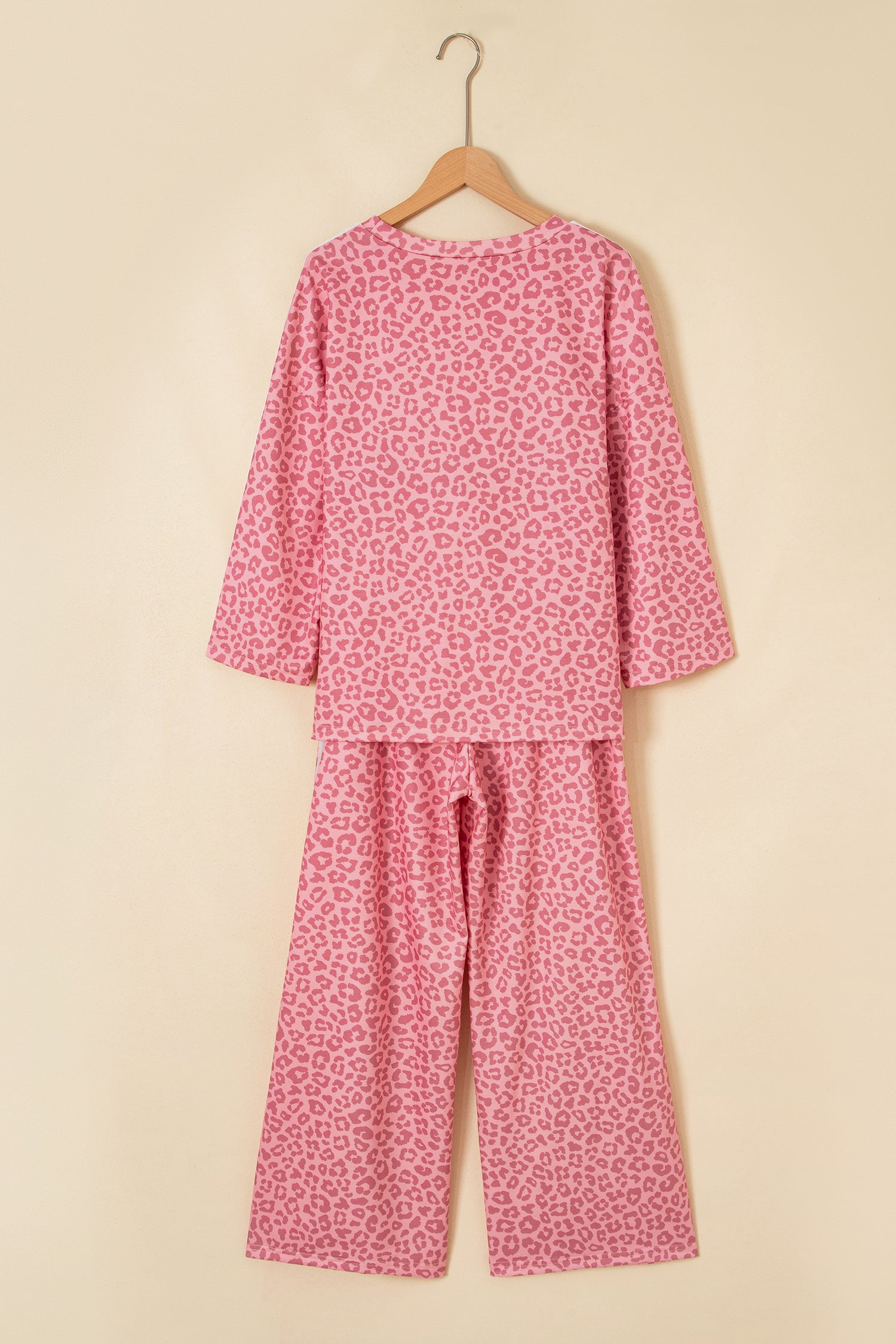 Pink leopard print top and pants set on a hanger, back view