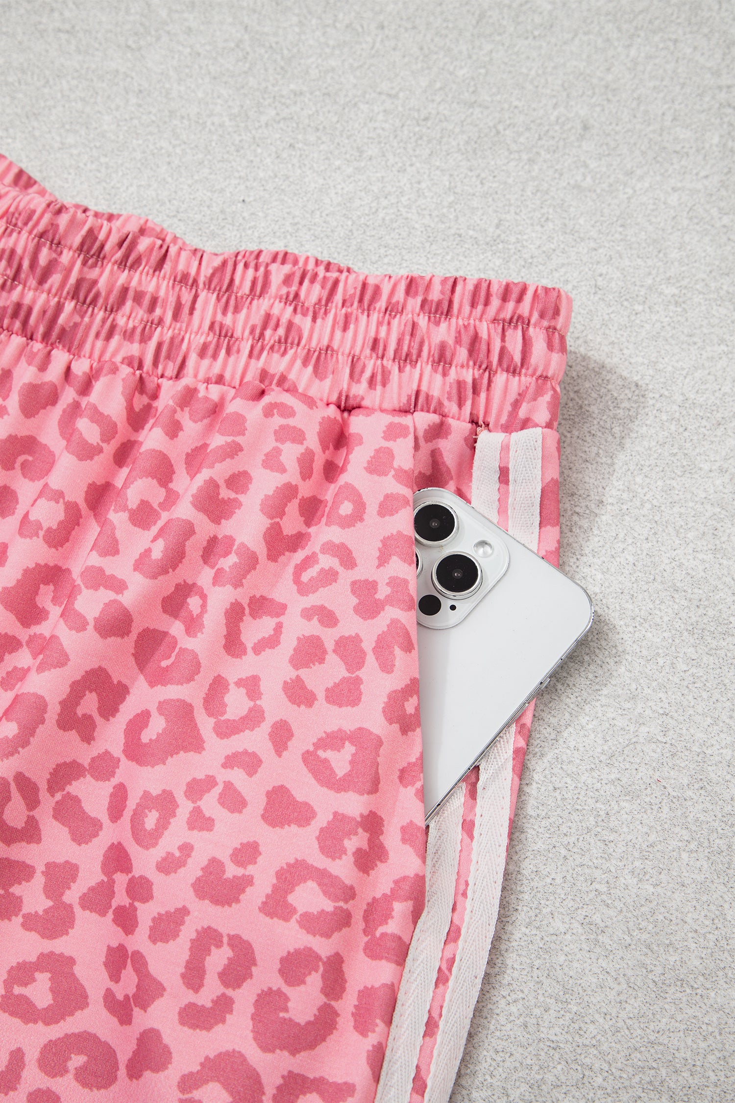 Pink leopard pants side pocket holding a phone