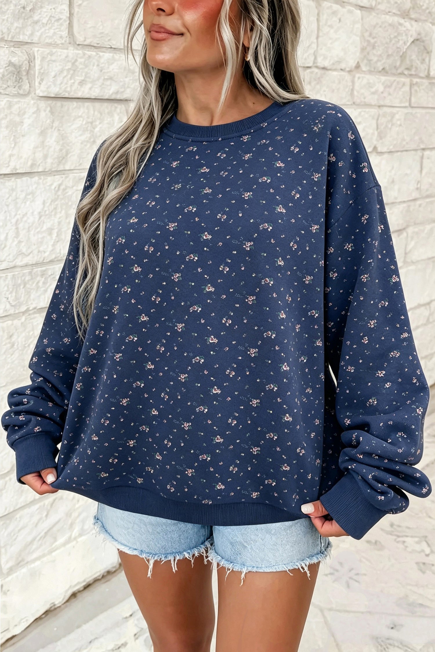 Women's navy floral print oversized sweatshirt, front view with denim shorts
