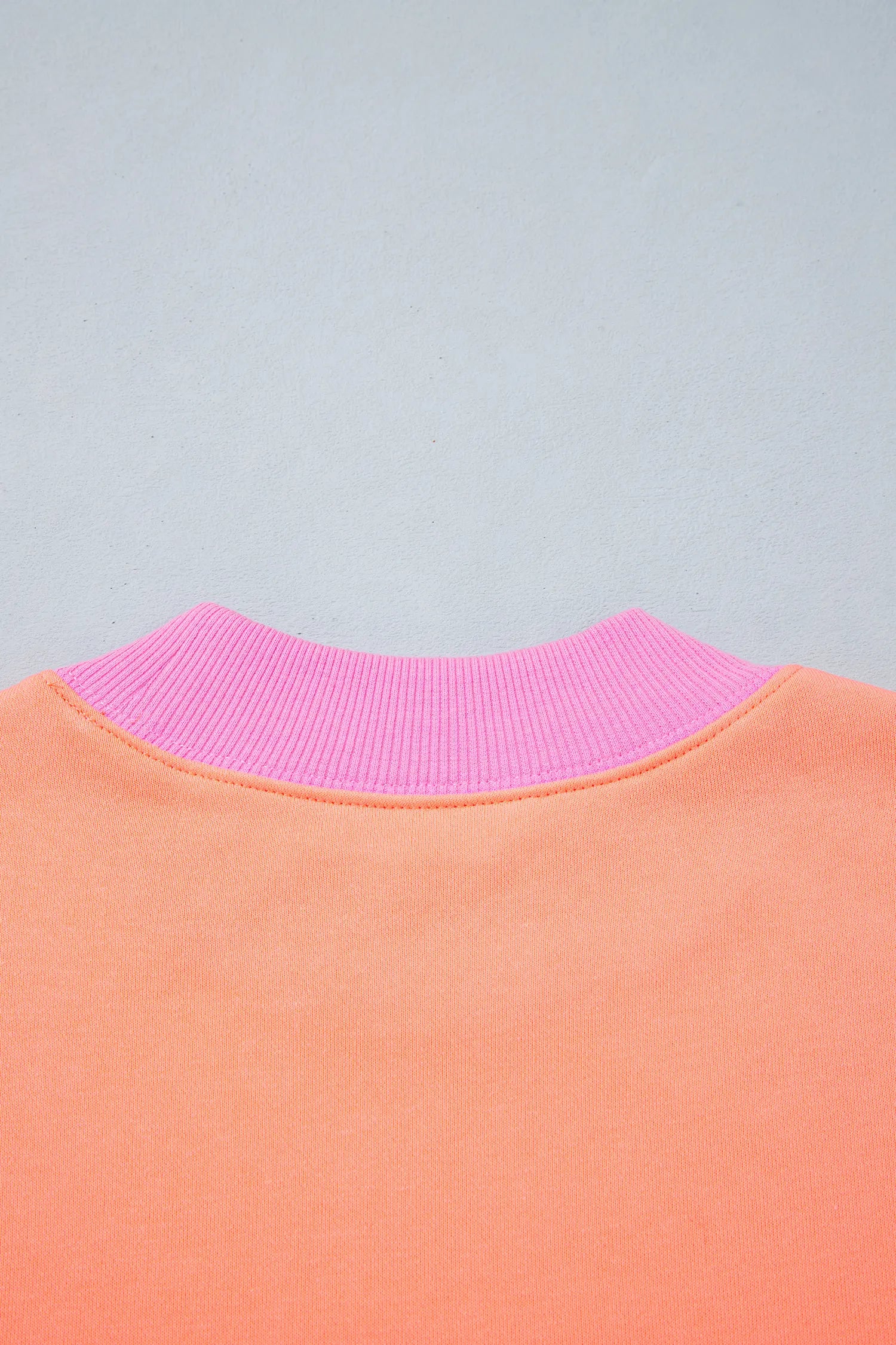 Orange sweatshirt pink ribbed back neckline detail