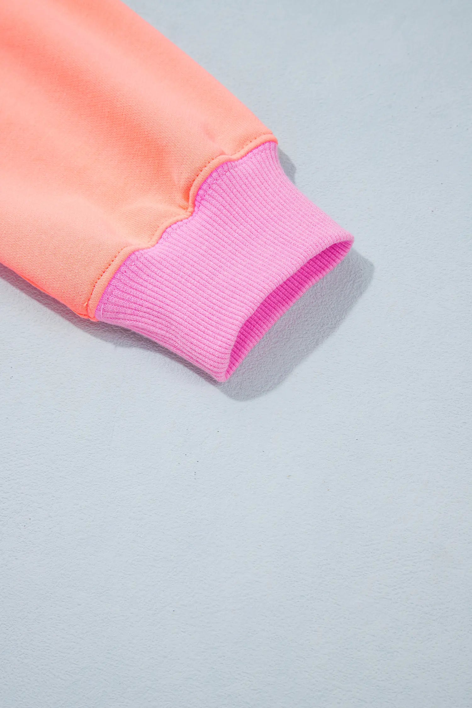 Close-up of orange sleeve with pink ribbed cuff