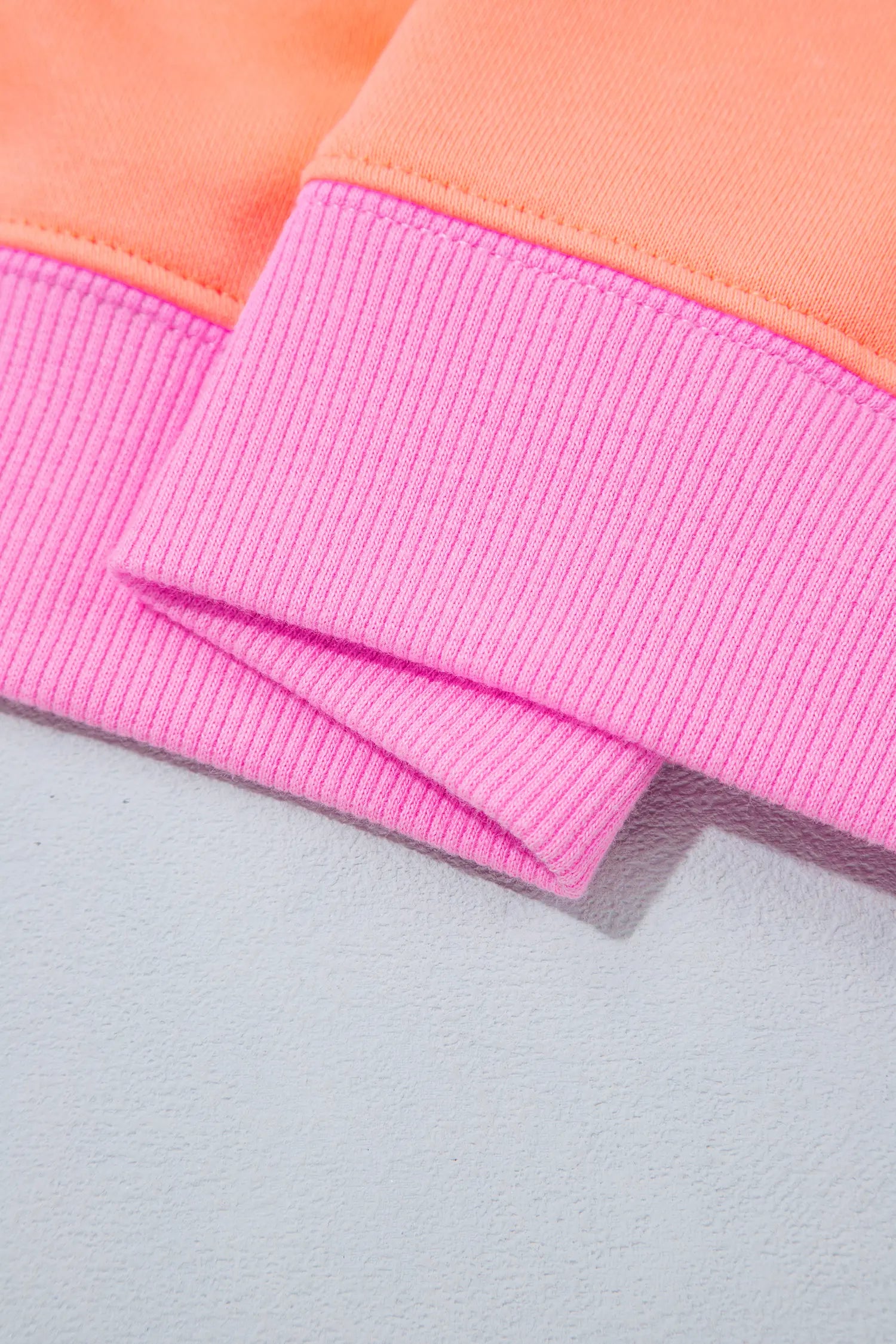 Orange sweatshirt with pink ribbed hem detail
