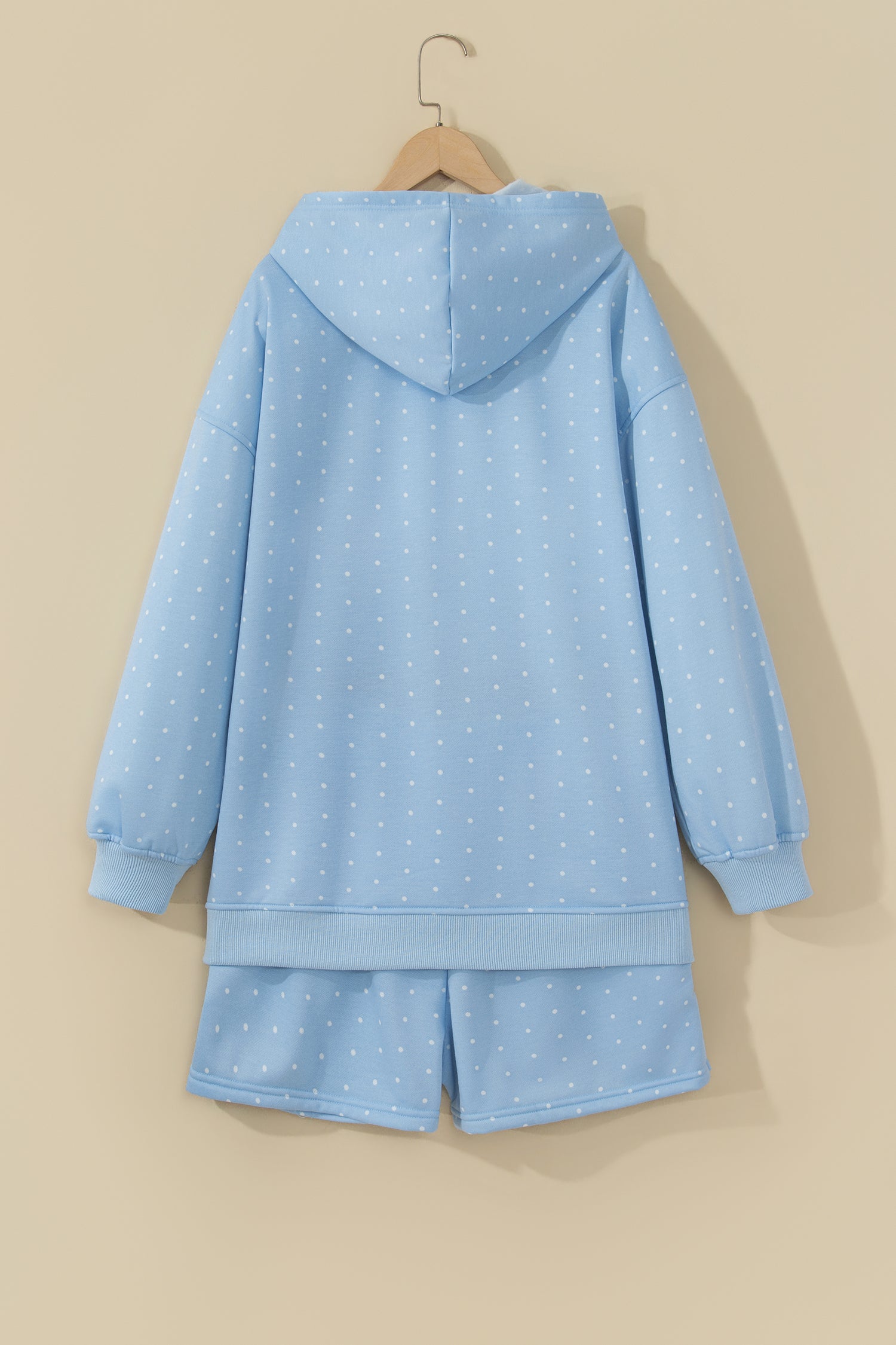 Sky blue polka dot hoodie and shorts set on a hanger, back view