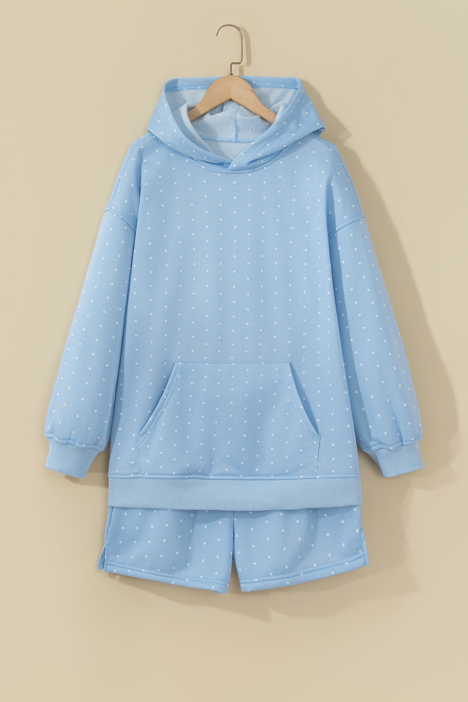 Sky blue polka dot hoodie and shorts set on a hanger, front view
