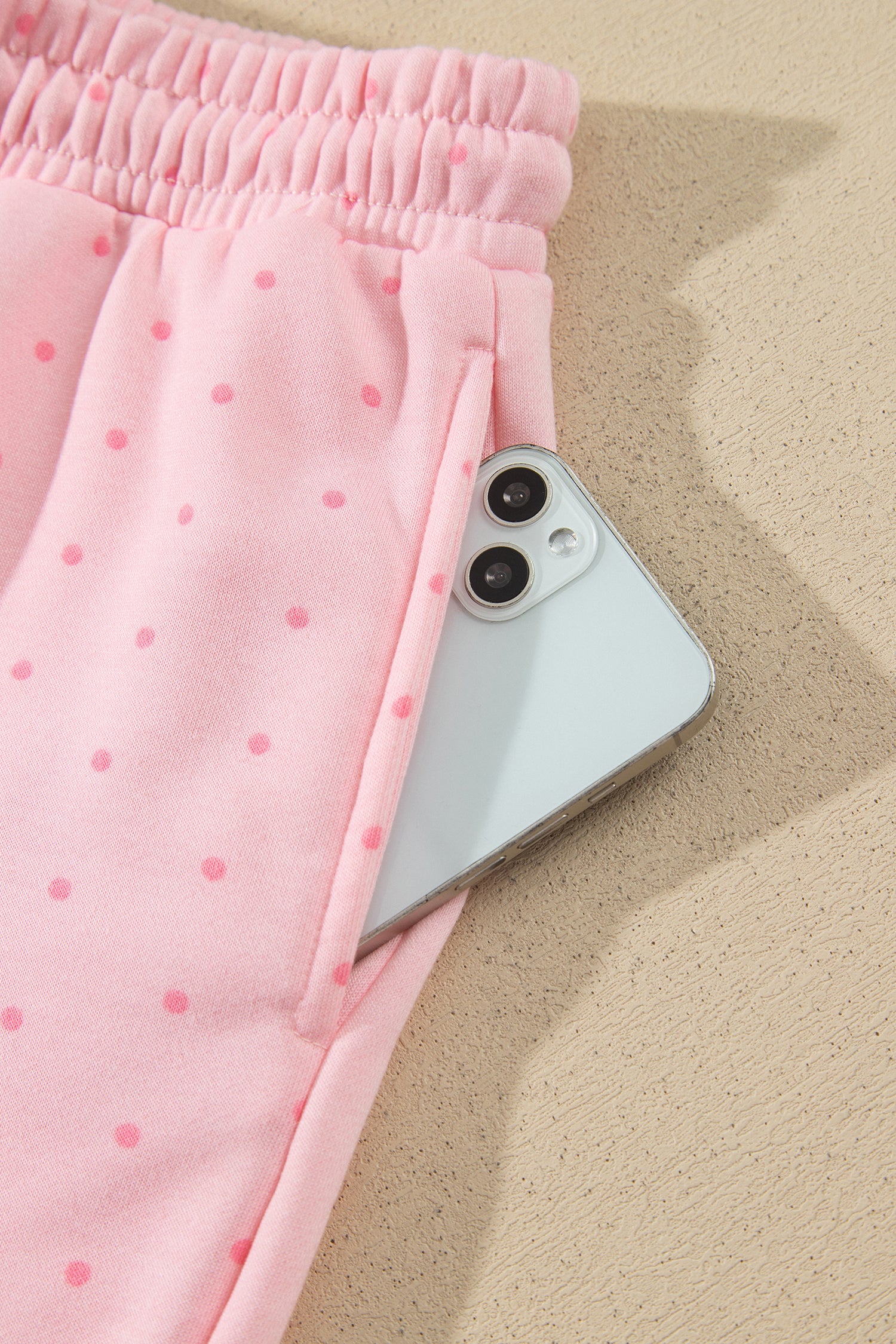 Pink polka dot shorts side pocket holding a phone