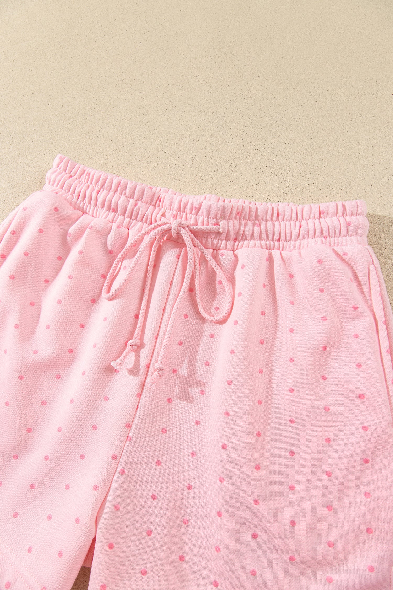 Pink polka dot drawstring shorts, flat lay