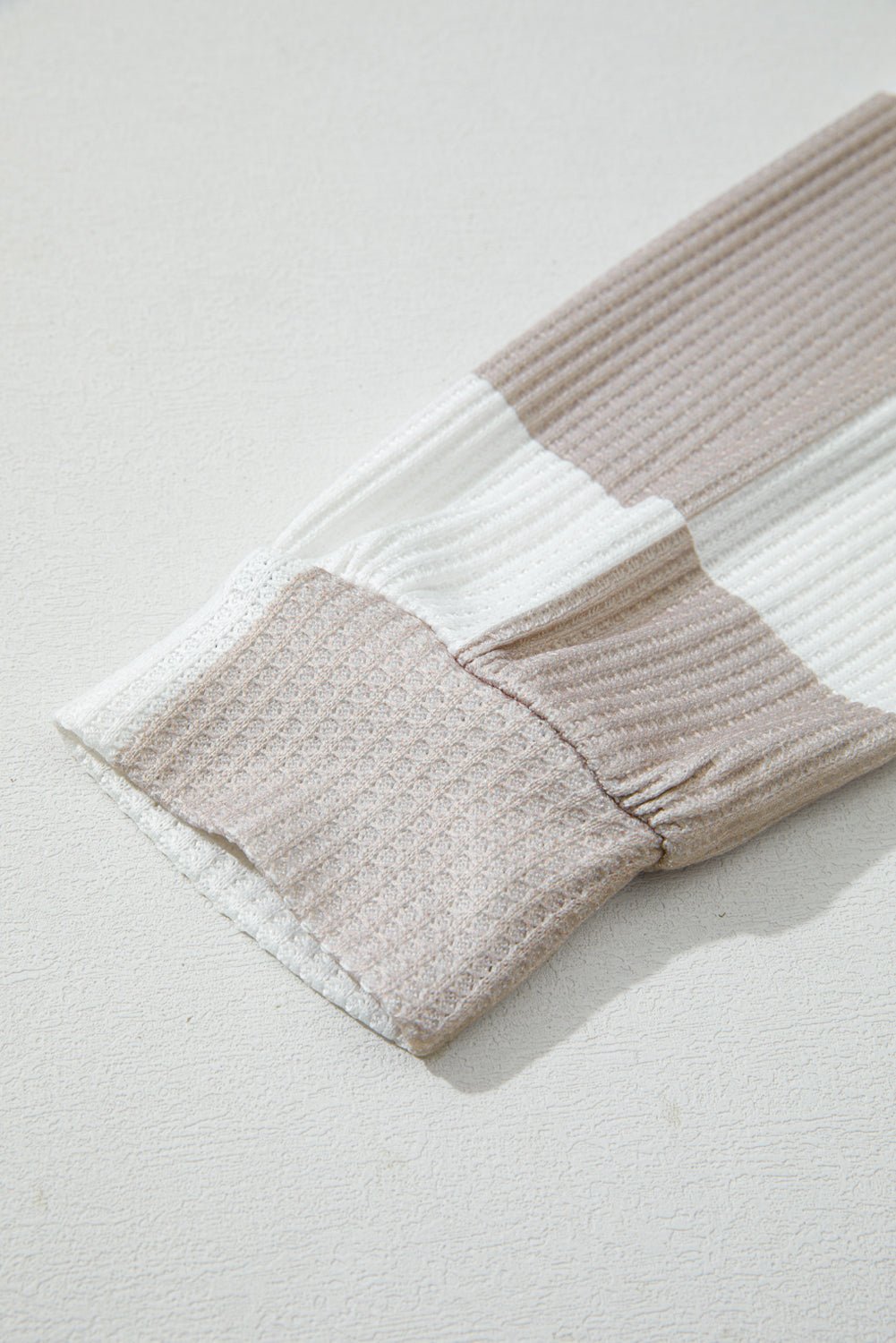 Textured blanket with wavy pattern on a light gray background