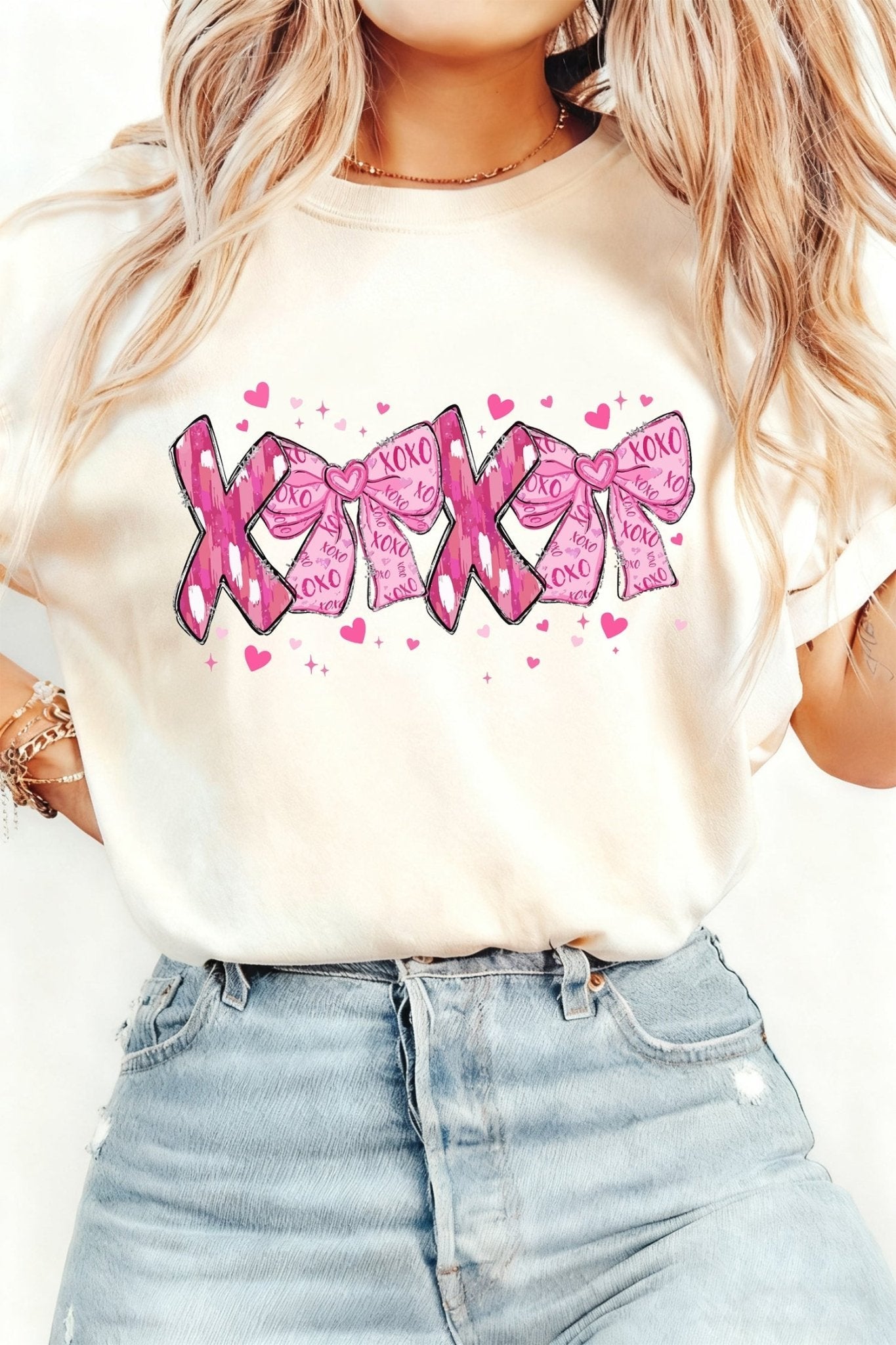 Person wearing a white t-shirt with pink ribbon design and text.