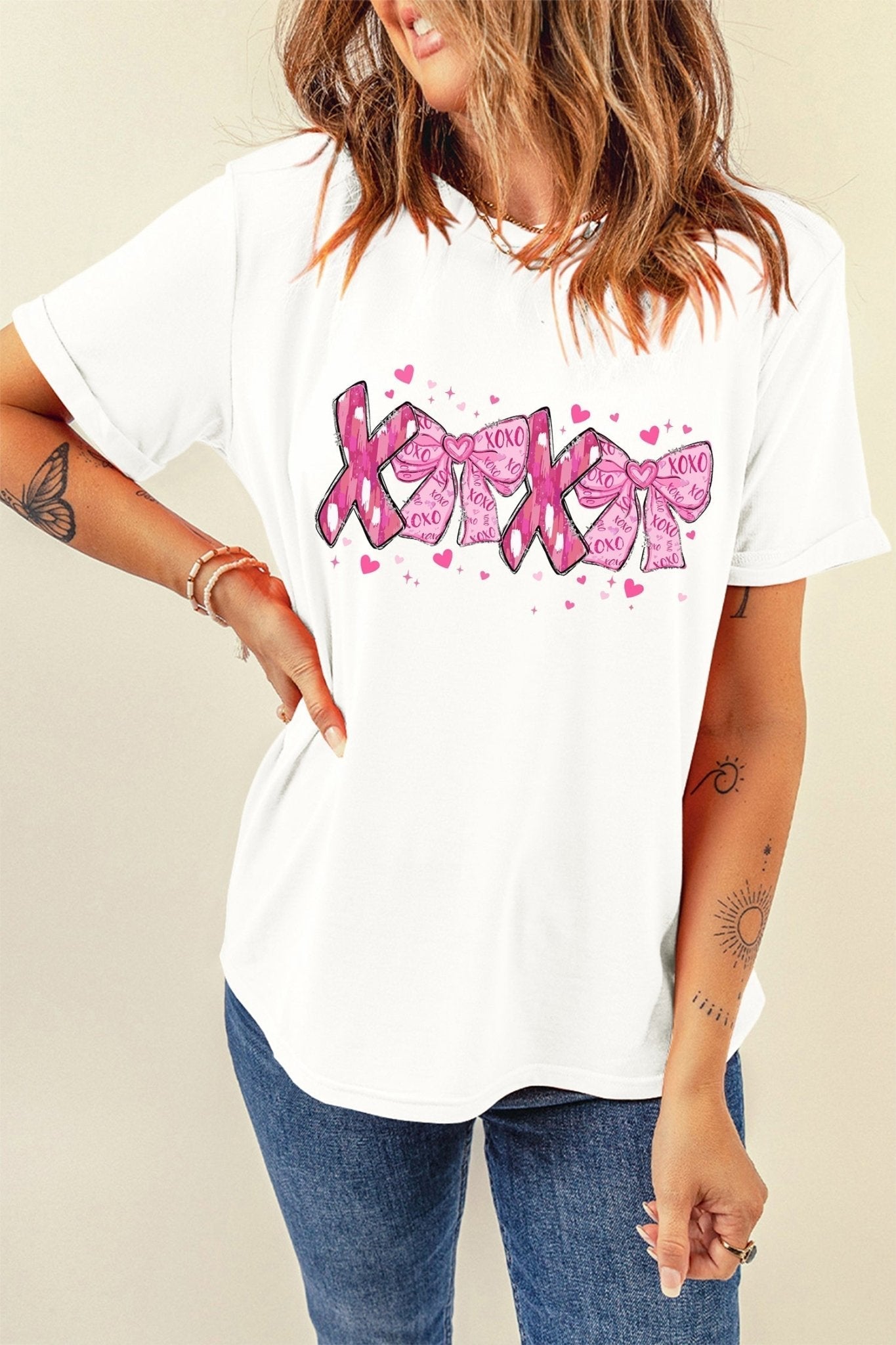Person wearing a white t-shirt with pink graphic design on a beige background