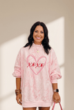 Woman wearing a pink tie-dye sweatshirt with 'xoxo' design on a neutral background