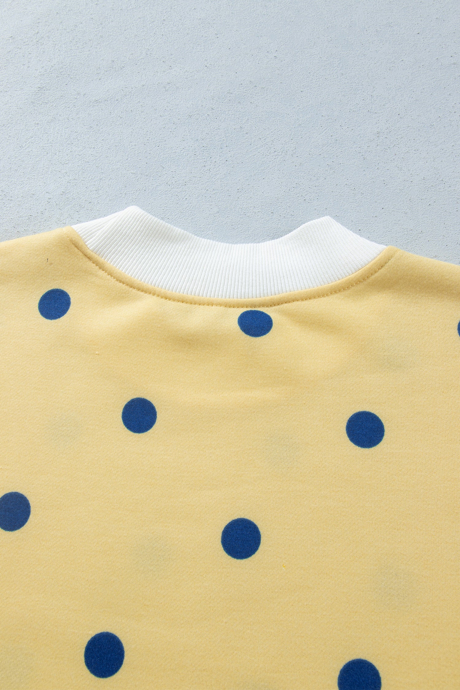 Back ribbed neckline detail on yellow polka dot top