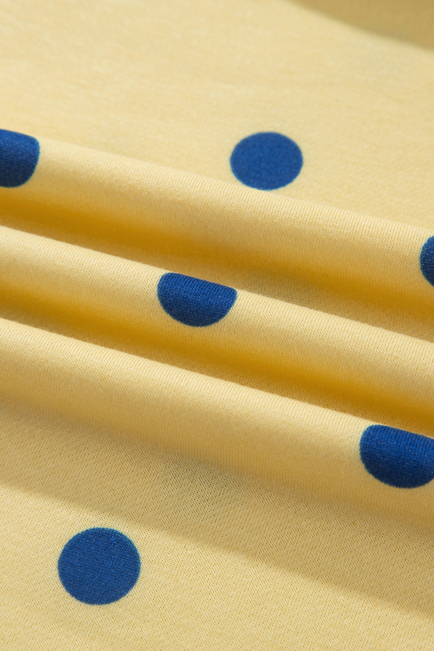 Polka dot print fabric texture on yellow set, close-up