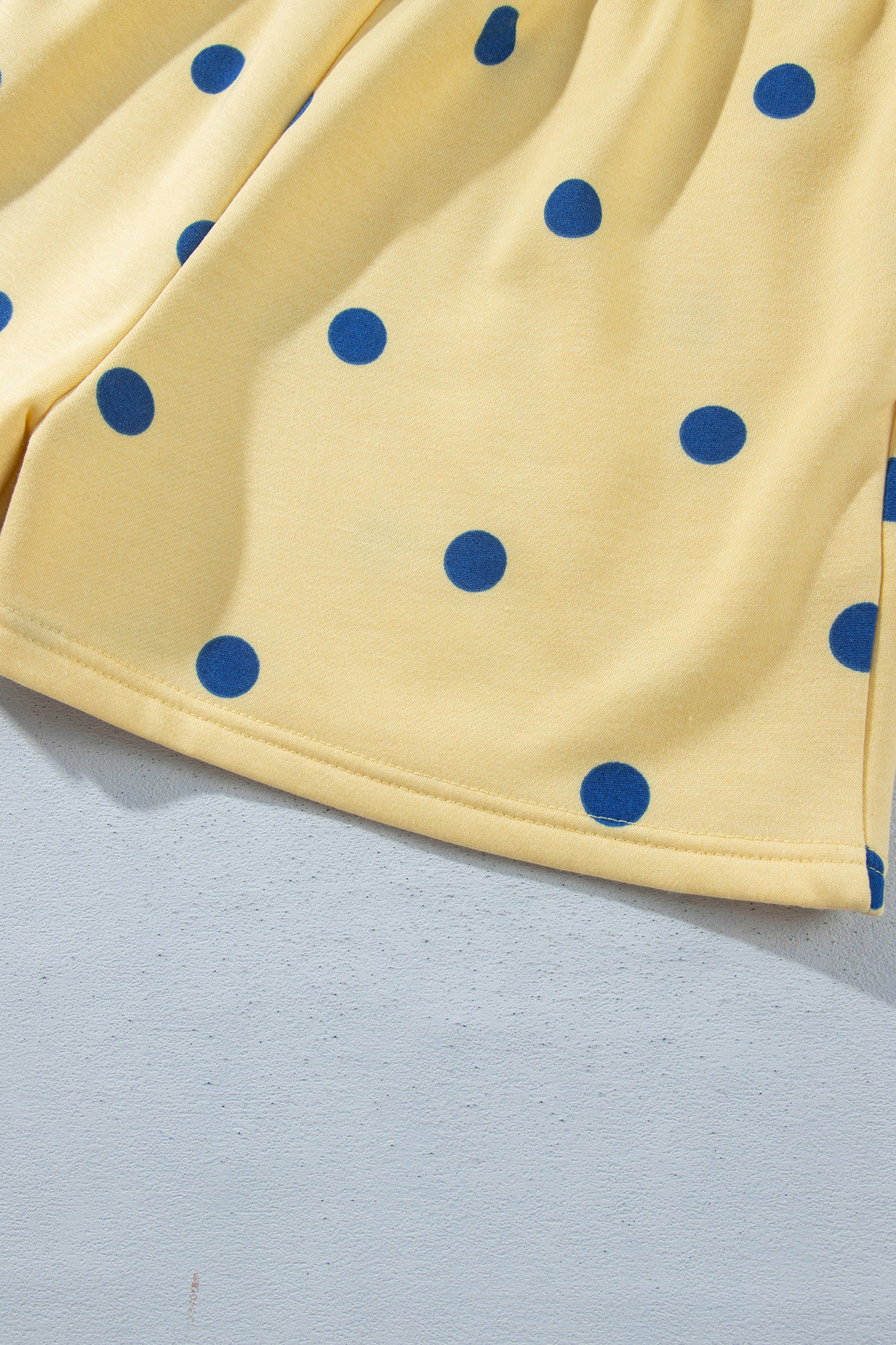 Hem detail of yellow polka dot shorts