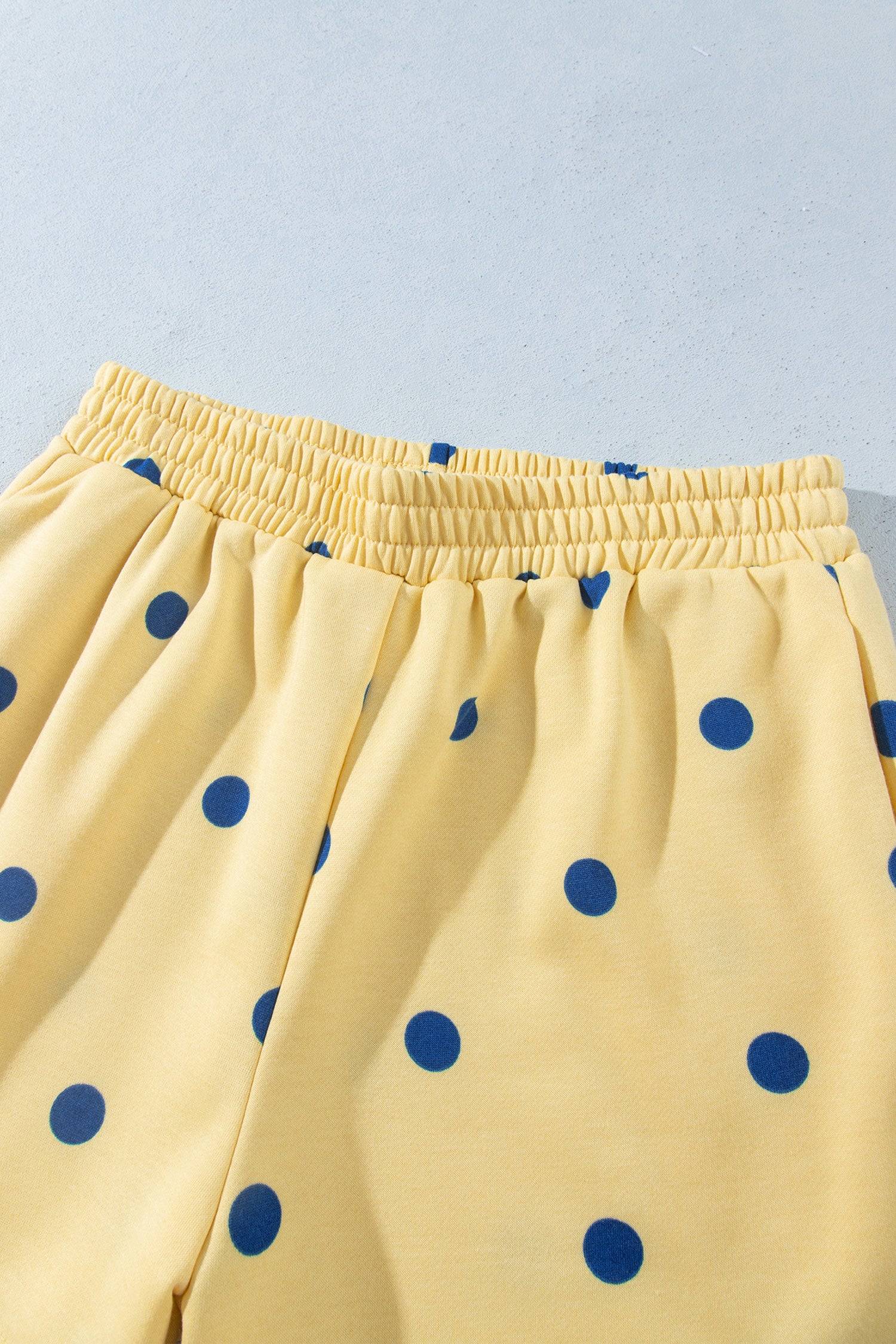 Elastic waistband on yellow polka dot shorts, close-up