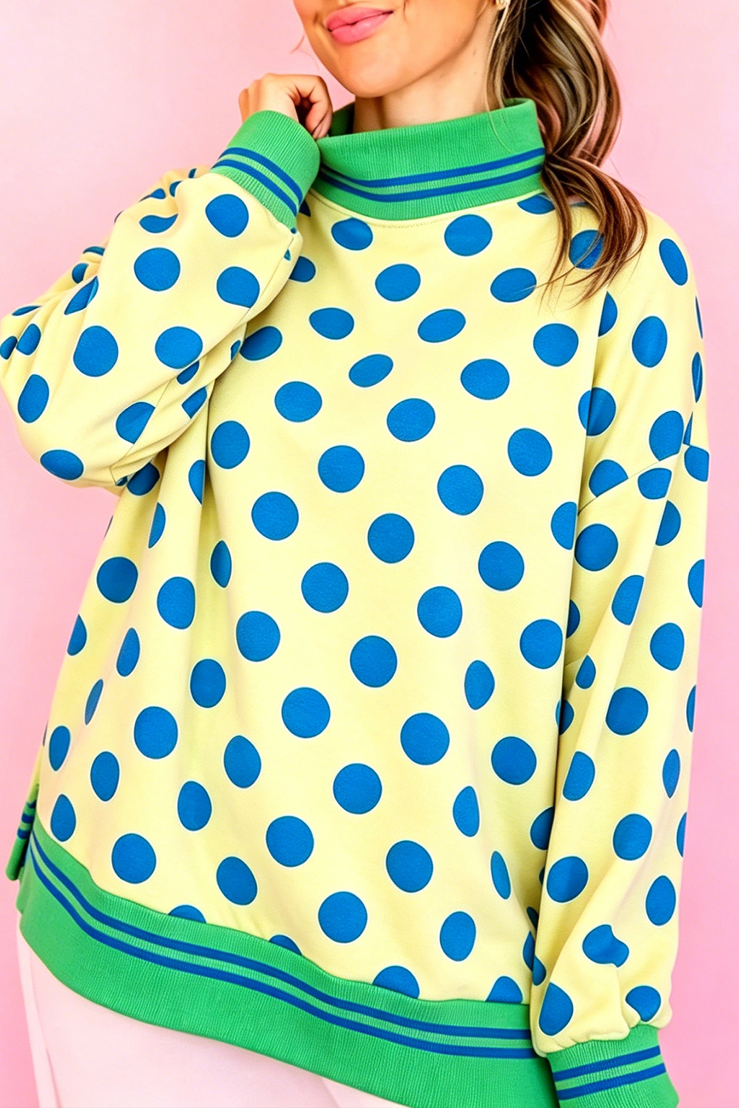 Yellow mock neck sweatshirt with blue polka dots and green striped trim, front view